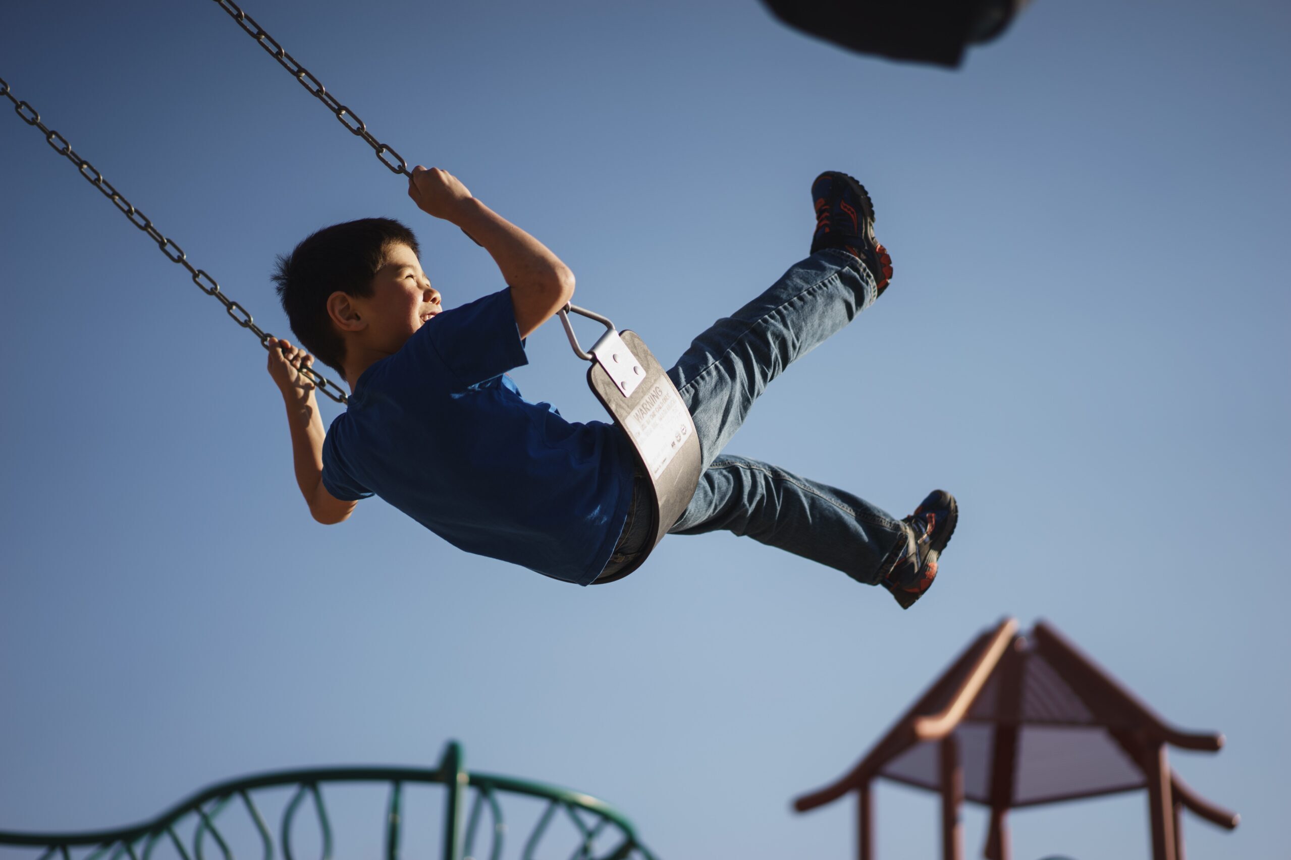 A boy on a park swing thinking about children's therapy in Oakville Ontario, Markham, North York and Vaughn.